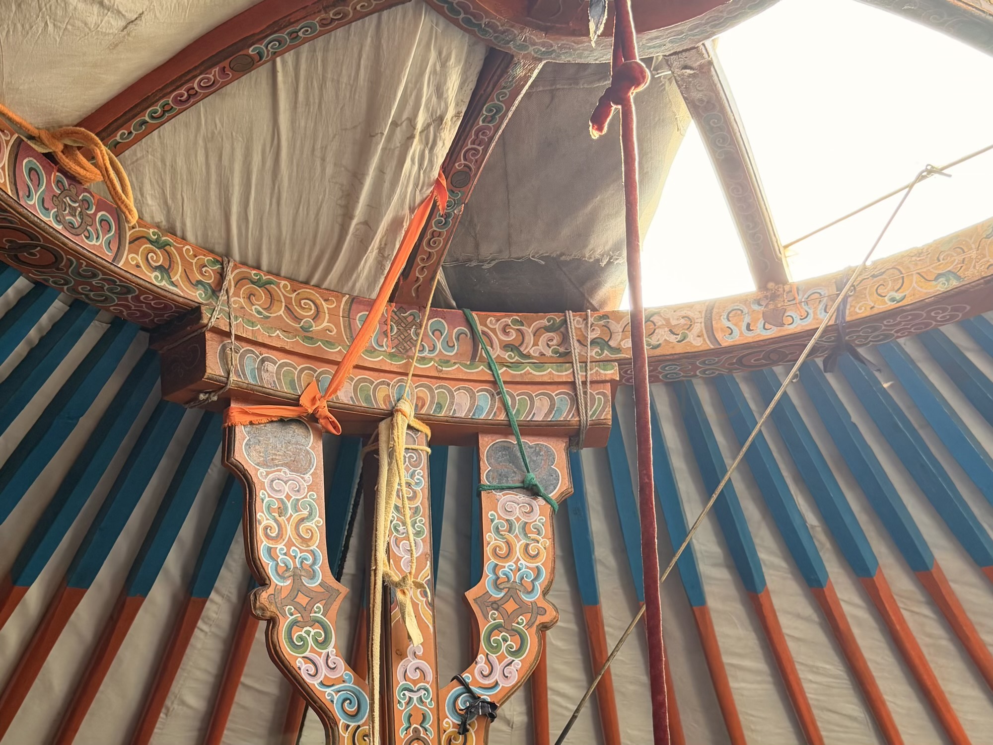 Chuluunbaatar racehorse trainer camp: The toono, the painted wooden crown at the top of the ger, lets light in and doubles as a rough sundial during the day. (Ger roof interior)
