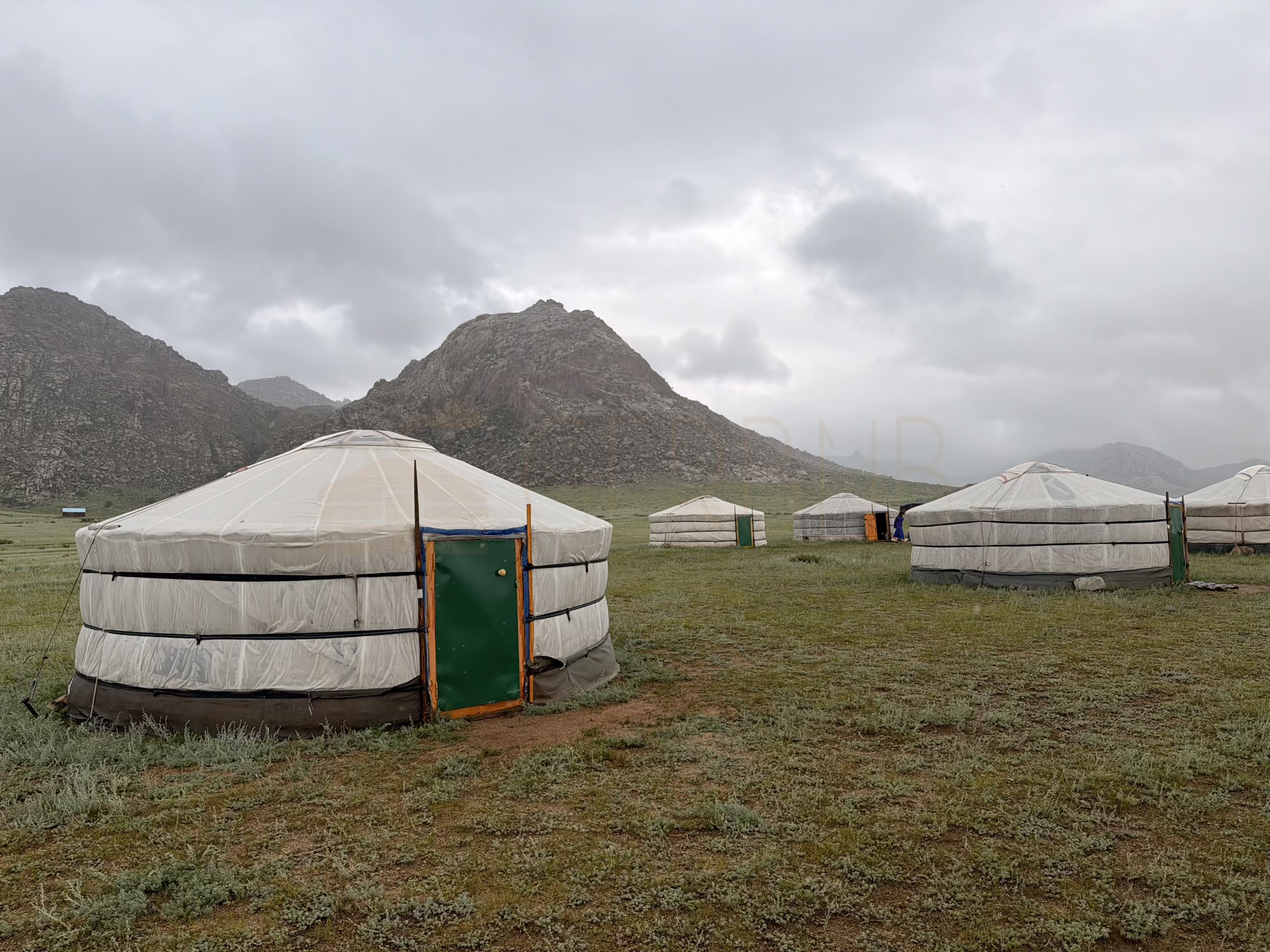 Bolor-Erdene Elsen Tasarkhai sand dune camp: The guest gers stand on open grassland below the rocky Khugnu Tarna mountains, away from the asphalt road. (Surrounding)