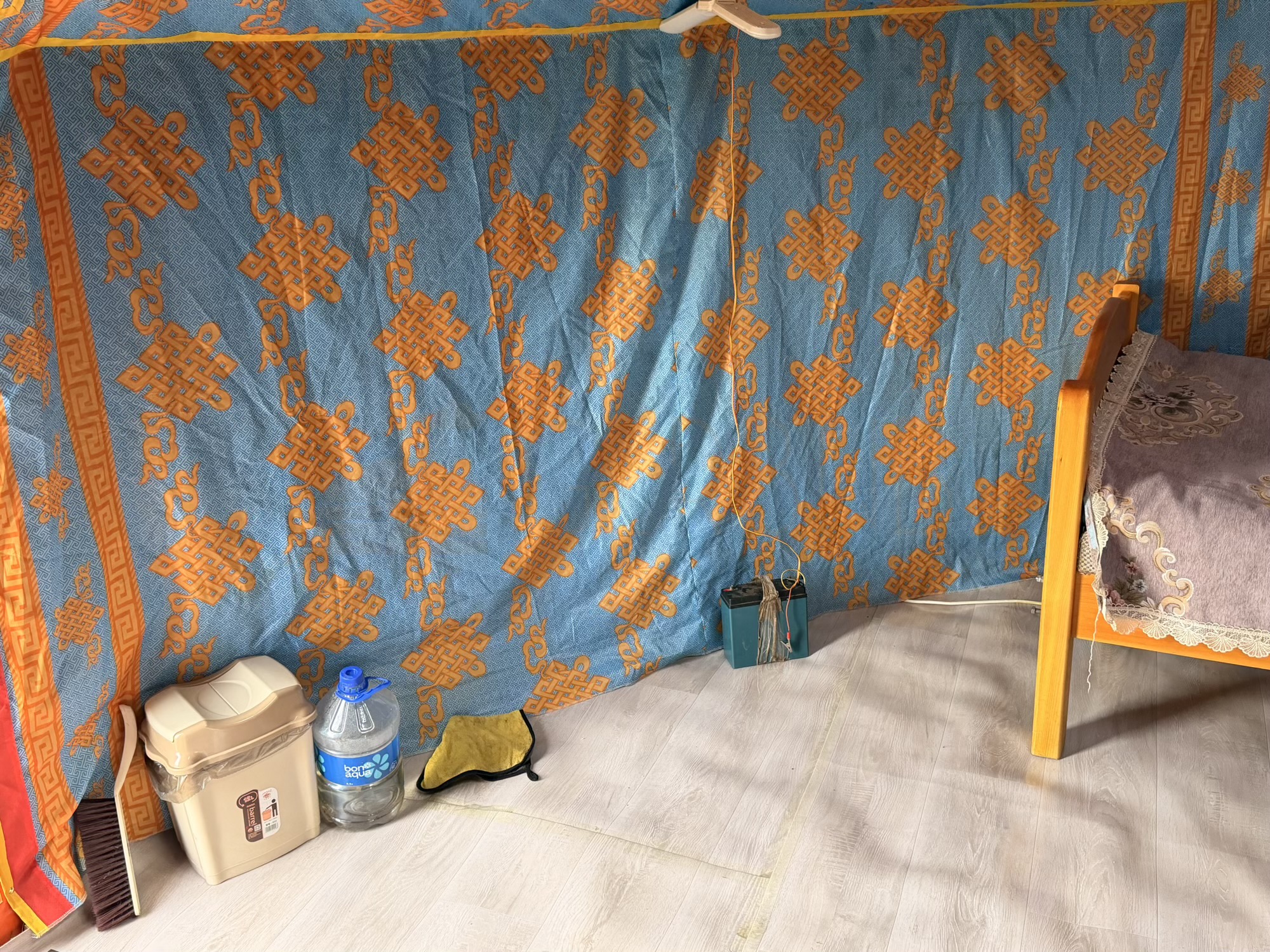 Myagmarsuren Shankh Monastery camp: A broom, trash bin, and battery accumulator for lighting sit tucked in the corner, part of the ger's everyday setup. (Ger essentials)