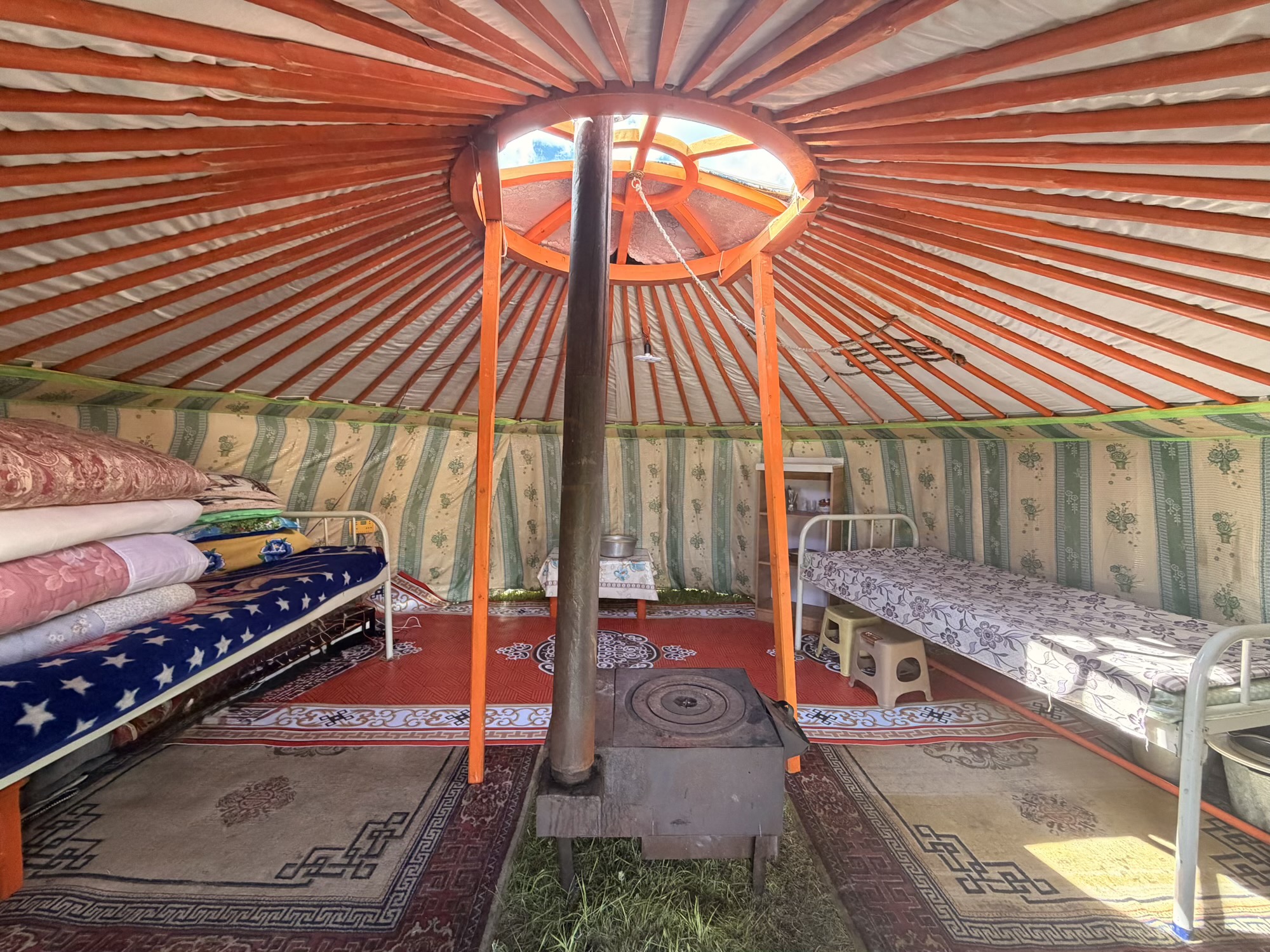 Batzaya camp: Inside the ger: a warm, well-insulated place to rest. The central stove heats up the space quickly, making it cozy even on chilly nights. (Interior, Bedding, Stove)