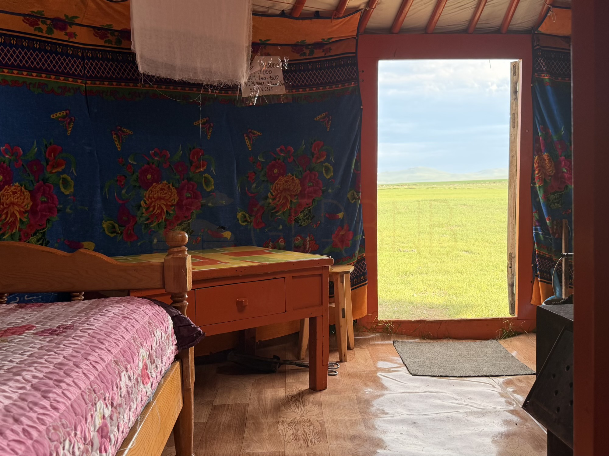 Togtohbayar Shankh monastery camp: A small table by the door catches the green steppe view, good for meals or writing postcards. (Table, doorway view)